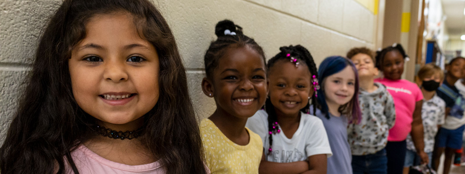 Smiling kindergarten students standing in hall