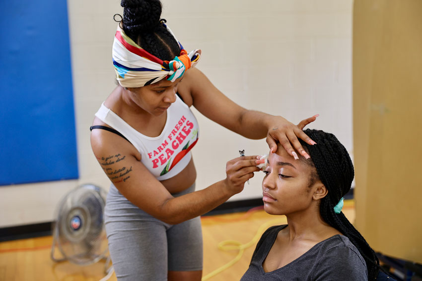 Salon owner shaping student's eyebrows