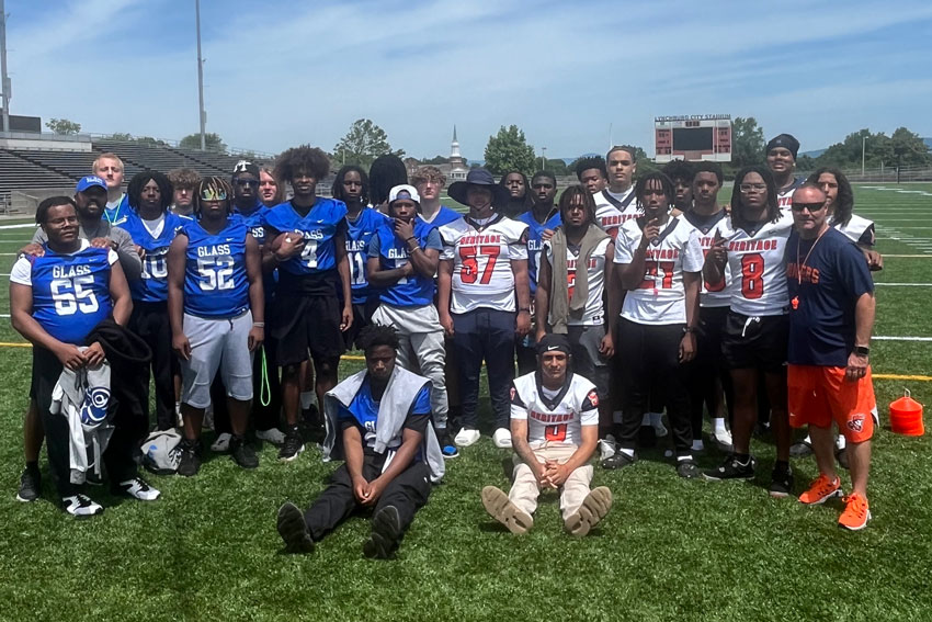 E. C. Glass and Heritage football players together on field after youth camp