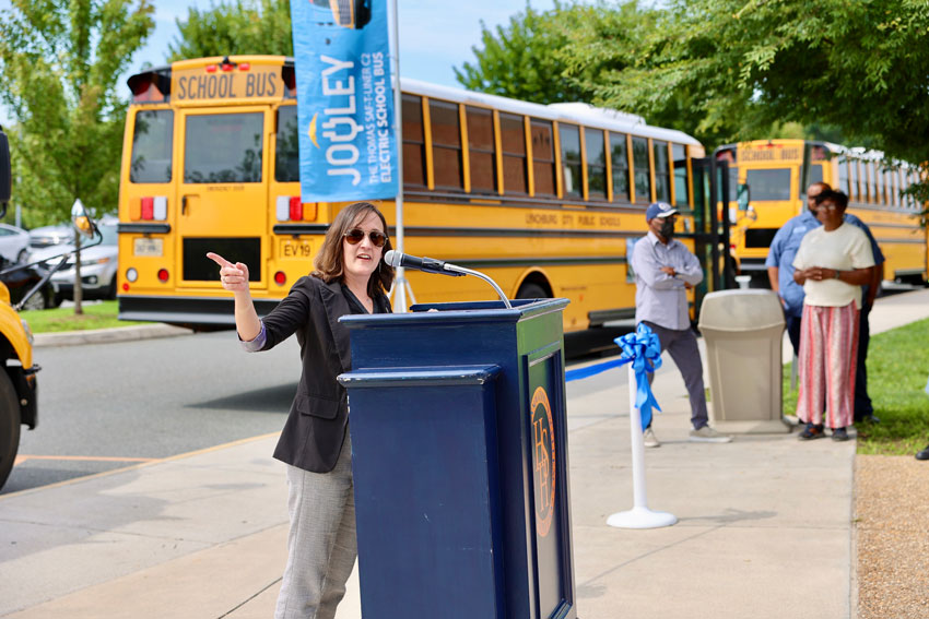 Director of Transportation speaking at podium during EV bus ceremony