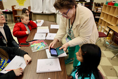 Teacher photographing student's concept sketch