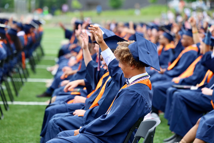 Graduates in caps and gowns seated at commencement ceremony