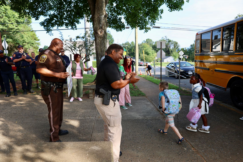 Policer officer, sheriff deputy and firefighters welcoming students to school