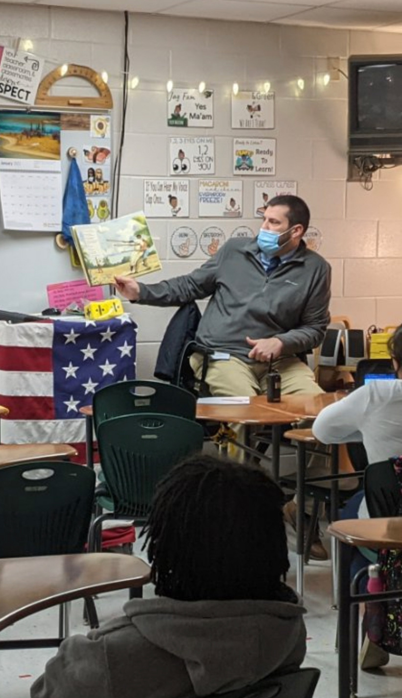 Assistant principal reading in front of class