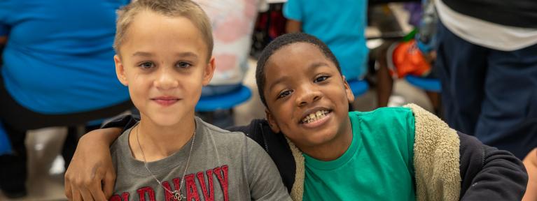 Two boys smiling at lunch